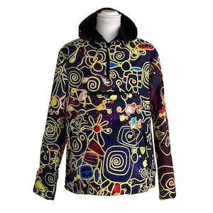 May include: A hooded anorak with a black faux fur-lined hood and a quarter-zip closure. The anorak features a vibrant, abstract design in yellow, blue, red, and white on a dark purple background. The anorak has a front pocket.