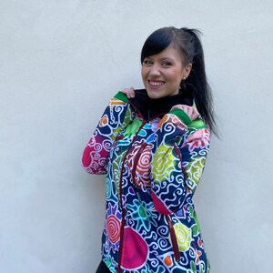 May include: A colourful jacket with a zip fastening and a swirling, abstract pattern in shades of blue, green, yellow, red, and pink.