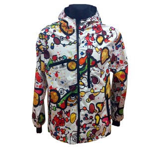 Op de afbeelding: Een wit jack met capuchon met een kleurrijke abstracte print. De print bevat een verscheidenheid aan vormen, lijnen en kleuren, waaronder rood, geel, blauw, groen en zwart. Het jack heeft een ritssluiting en twee zakken.