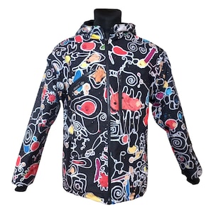 Puede incluir: Chaqueta negra con capucha y diseño abstracto colorido. La chaqueta tiene cremallera completa, capucha y un diseño con formas rojas, amarillas y azules. Hay un pequeño bolsillo en el pecho.