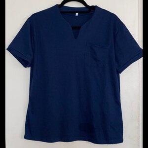 May include: A navy blue short-sleeved t-shirt with a v-neck and a single pocket on the left side.