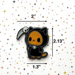 May include: A cartoon-style cat dressed as the Grim Reaper, holding a scythe with a skull. The cat is orange with black accents and a black hooded robe. The charm measures 2 inches wide, 2.13 inches tall, and 1.3 inches thick.