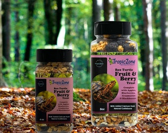May include: Two jars of Tropic Zone Box Turtle Fruit & Berry Treat. The smaller jar is 4 oz and the larger jar is 8 oz. Both jars contain a mix of dried fruits and berries. The jars are sitting on a bed of fallen leaves.
