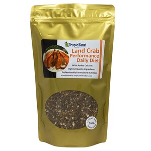 May include: A gold bag of Tropic Zone Land Crab Performance Daily Diet pet food with a picture of a land crab on the front. The bag is labeled with the text "With Added Calcium, Highest Quality Ingredients, Professionally Formulated Nutrition, Manufactured by TropicZoneProducts.com". The bag also has a label that says "Guaranteed Freshness 16oz".