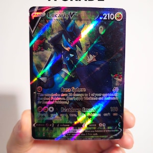 Op de afbeelding: Een holografische Pok&eacute;mon-verzamelkaart met Lucario V, een blauw en zwart Pok&eacute;mon met een humano&iuml;de vorm. De kaart heeft een zwarte achtergrond met een holografisch effect. De kaarttekst luidt "Aura Sphere" en "Beatdown Smash".