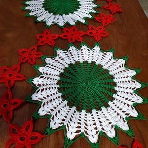 Puede incluir: Dos manteles individuales de ganchillo en verde, blanco y rojo. El mantel individual más grande está en el centro de la imagen y tiene un centro verde y blanco con un borde rojo. El mantel individual más pequeño está encima del más grande y tiene un centro blanco y verde con un borde rojo.