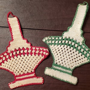 May include: Two crocheted pot holders in the shape of a basket. One is red and white, the other is green and white.