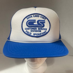 May include: A white and blue trucker hat with a blue embroidered logo that reads "Data Card Corp. Customer Service Division Field Operations".