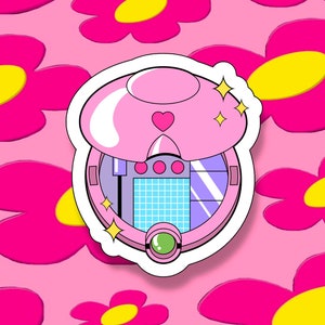May include: A pink and white compact mirror with a heart design and a blue and white grid pattern inside. The mirror is surrounded by a white sticker with sparkles.
