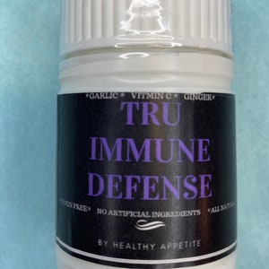 Puede incluir: Botella blanca con una etiqueta negra que dice "TRU IMMUNE DEFENSE" con las palabras "GARLIC VITMIN C GINGER" en la parte superior y "TOXIN FREE NO ARTIFICIAL INGREDIENTS ALL NATURAL" en la parte inferior. La etiqueta también incluye las palabras "BY HEALTHY APPETITE" en la parte inferior.
