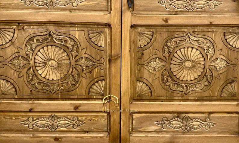 May include: A pair of wooden doors with intricate carved designs. The doors are a light brown color and have a brass handle.