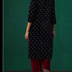 May include: A navy blue velvet kurta with silver embroidery and a maroon velvet salwar with silver embroidery.