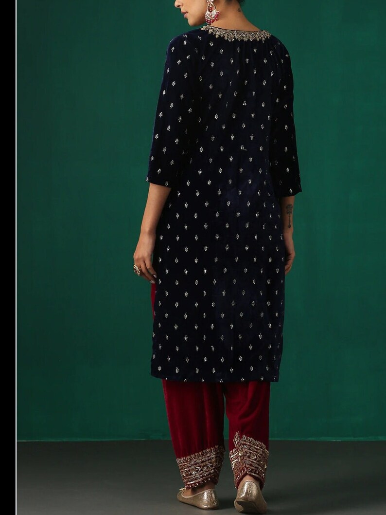May include: A navy blue velvet kurta with silver embroidery and a maroon velvet salwar with silver embroidery.