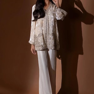 Traje de pantalón y blazer de terciopelo marfil: atuendo de invitada de boda con cuentas