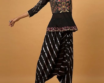 May include: A black and white tie-dye palazzo pant with a black embroidered top featuring gold and red embellishments. The top has a V-neckline and a peplum waist.