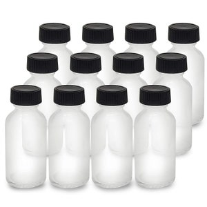 May include: Ten clear glass bottles with black screw-on lids. The bottles are all the same size and shape, and they are arranged in a staggered pattern.