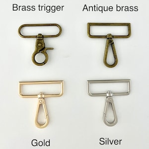 May include: Four different types of metal trigger clasps.  The clasps are in brass trigger, antique brass, gold, and silver finishes.  Each clasp has a rectangular loop and a trigger hook.
