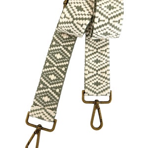 Op de afbeelding: Een geweven band met een groen en wit patroon en messing gespen. De band is ongeveer 122 cm lang.