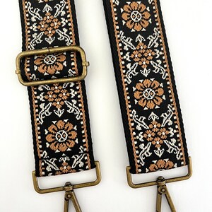 May include: Two black and brown patterned guitar straps with gold metal clasps and hooks.