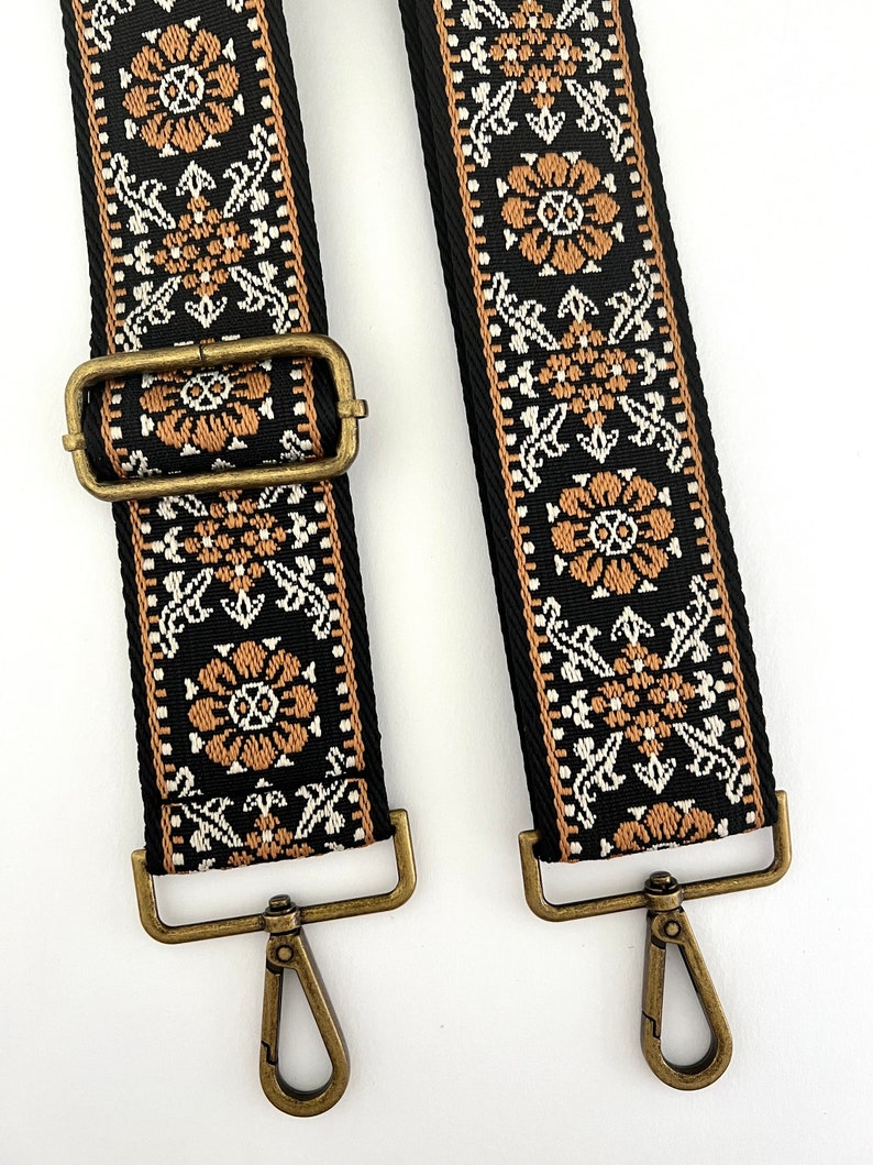 May include: Two black and brown patterned guitar straps with gold metal clasps and hooks.