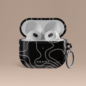 Pode incluir: Estojo para fones de ouvido sem fio com padrão preto e branco com um logotipo branco que diz "SALA VISA" e um anel prateado preso ao estojo.