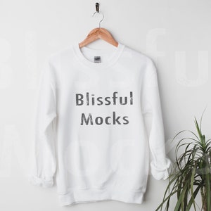 May include: White crewneck sweatshirt with the text "Blissful Mocks" printed in black on the front.