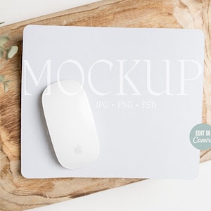 以下が含まれることがあります： 白いコンピューターマウスが、明るい灰色のマウスパッドの上に置かれています。マウスパッドには、大きなエレガントなフォントで「MOCKUP」という文字が印刷されています。マウスパッドは木製の表面にあります。「JPG PNG PSD」という文字も表示されています。