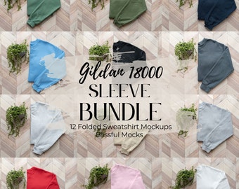 May include: Twelve folded Gildan 18000 sweatshirts in various colors, including red, blue, green, gray, black, and white. The sweatshirts are folded and arranged on a wooden surface. The text "Gildan 18000 Sleeve Bundle" and "12 Folded Sweatshirt Mockups" is visible in the image.