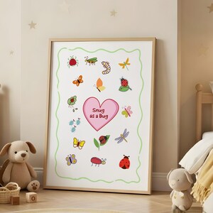 May include: A framed print featuring colorful cartoon insects and the text "Snug as a Bug" on a pink heart. The artwork includes ladybugs, butterflies, and dragonflies, with a green border. The print is displayed in a child's bedroom.