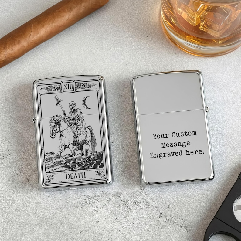 May include: Two silver lighters. One features a Death tarot card design with a skeleton on horseback, the other is blank with the text "Your Custom Message Engraved here."