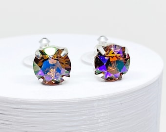 May include: A pair of silver earrings with iridescent brown and purple rhinestones.