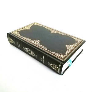 May include: A black hardcover book with a gold decorative border and the title "The Adventures of Sherlock Holmes" on the spine.