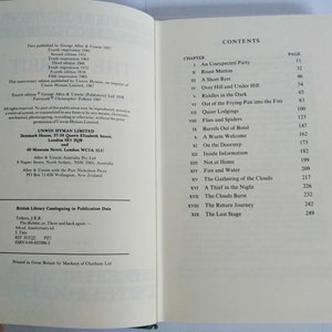 K&ouml;nnte beinhalten: Ein Buchcover mit dem Titel "Der Hobbit" und dem Autor "J.R.R. Tolkien". Das Cover ist dunkelgr&uuml;n mit einem goldenen Rand und zeigt eine stilisierte Illustration eines Hobbits mit einer Pfeife und einem Spazierstock.