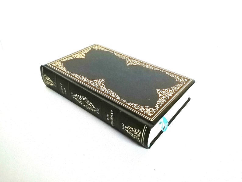 May include: A black hardcover book with a gold decorative border and the title "The Adventures of Sherlock Holmes" on the spine.