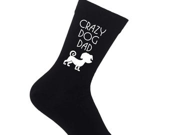 May include: Black sock with the text "CRAZY DOG DAD" in white, along with a white illustration of a dog. The sock is made of a soft material and is designed to fit the foot and ankle.