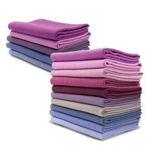 Könnte beinhalten: Ein Stapel von Stoffproben in Lila, Rosa und Blau. Die Proben sind gefaltet und in einem Farbverlauf von Dunkelviolett bis Hellblau angeordnet.