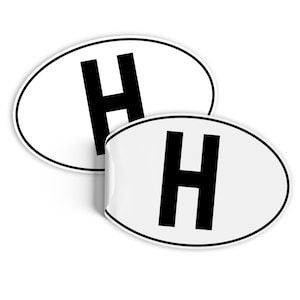 May include: Two white oval stickers with a black letter H in the center.