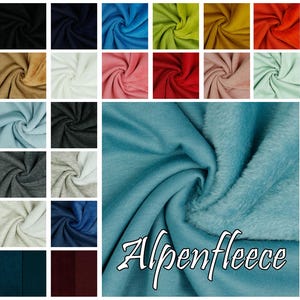 Peut inclure: Un assortiment d'échantillons de tissu dans différentes couleurs, notamment bleu, vert, rouge, rose et marron. Le tissu est en polaire doux et moelleux. Le texte "Alpenfleece" est écrit en blanc sur le tissu.