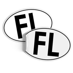 Może przedstawiać: Dwa białe owalne naklejki z czarnym napisem. Naklejki mają napis "FL" pogrubioną czcionką bezszeryfową.