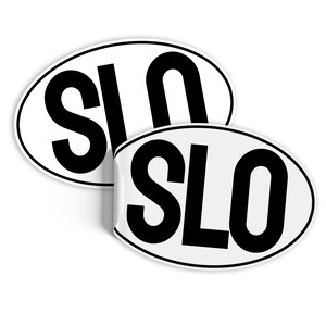 Może przedstawiać: Dwa białe owalne naklejki z czarnym tekstem, który brzmi "SLO".