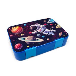 Op de afbeelding: Blauwe lunchbox met een ruimtethema-ontwerp. De lunchbox heeft een astronaut die in de ruimte zweeft met planeten en sterren. De lunchbox heeft twee sluitingen aan de voorkant.