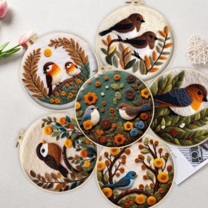 May include: A collection of five embroidered bird art pieces in wooden hoops. Each piece features colorful birds perched on branches with flowers and foliage. The artwork showcases various bird species in a detailed, textured style.
