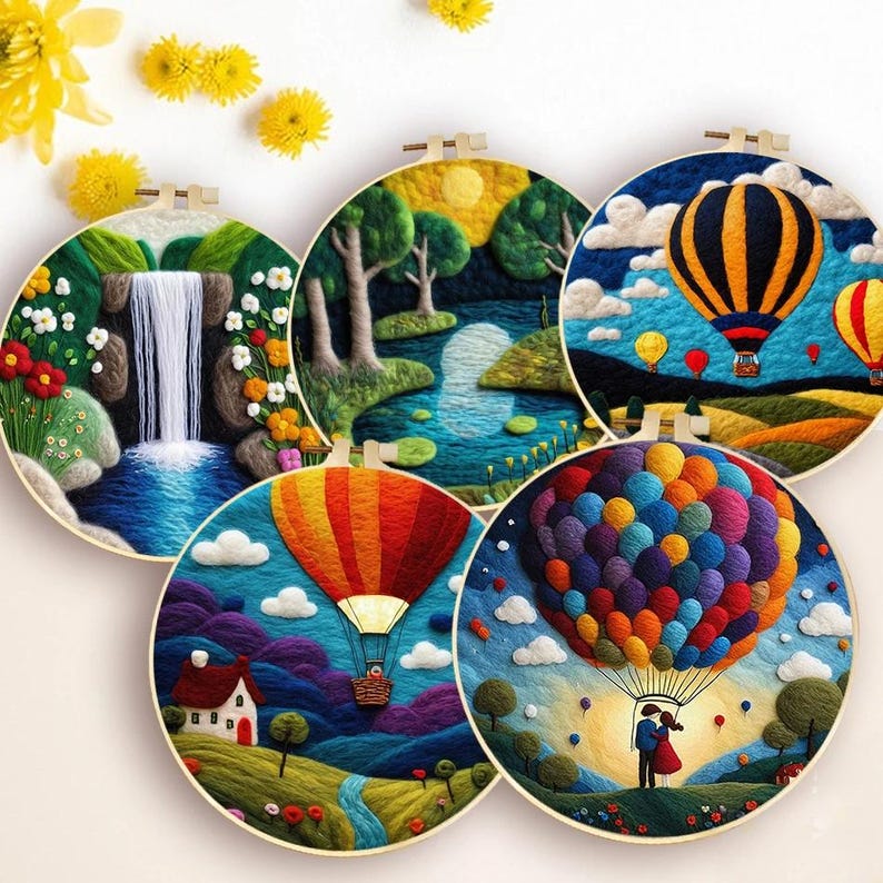 May include: Five round embroidery hoops featuring colourful wool felt designs. The designs include a waterfall, a forest scene, hot air balloons, a house with a hot air balloon, and a couple holding hands in a hot air balloon.