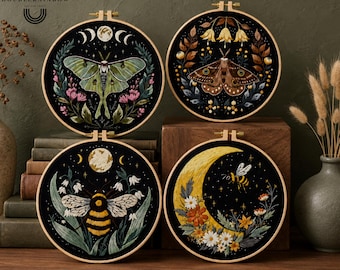 May include: Four circular embroidery hoops featuring black fabric with detailed needlework. Designs include a green moth with moon phases, a brown moth with floral accents, a bumblebee with white flowers, and a yellow crescent moon with a bee.