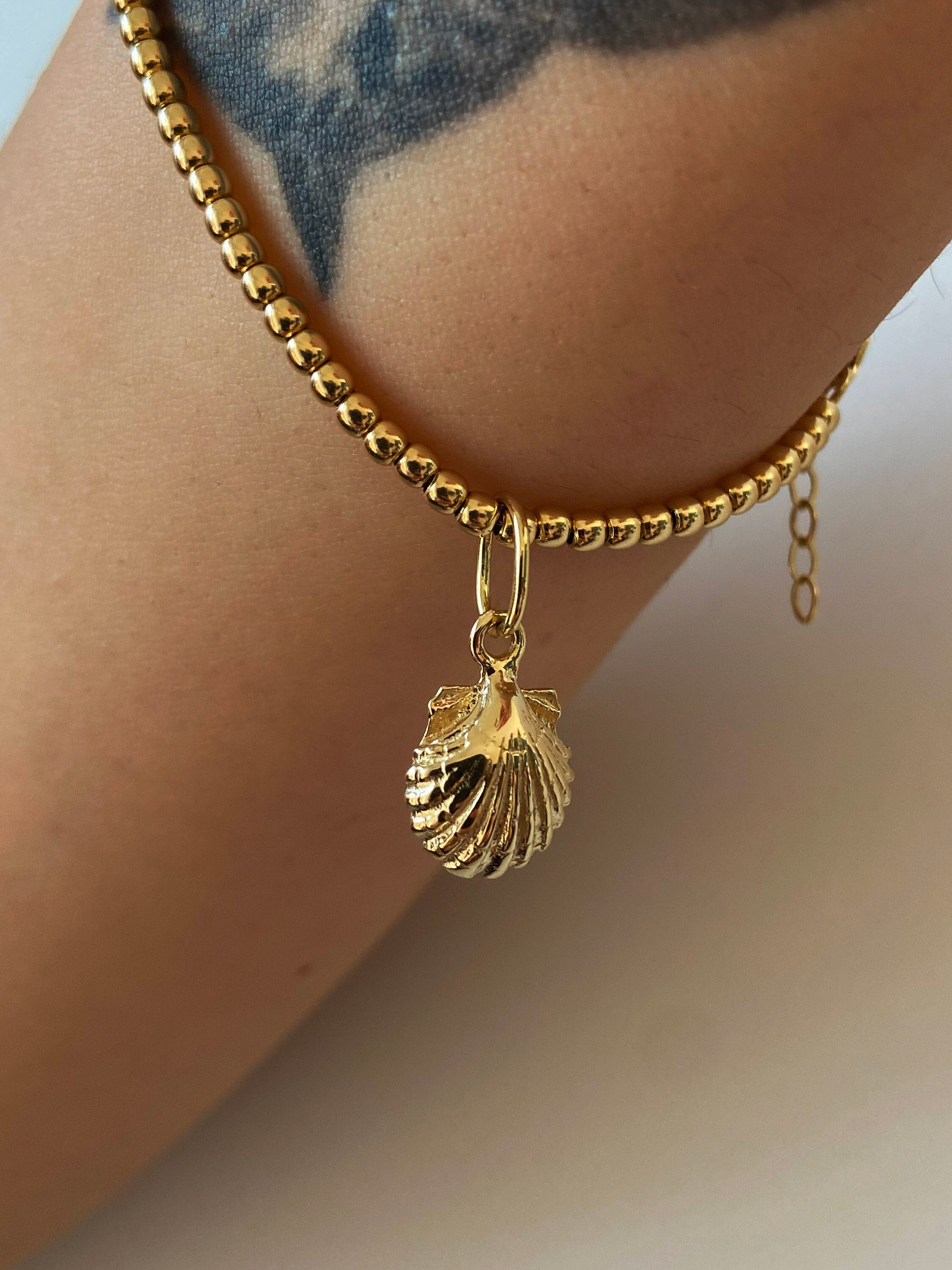 Gold shell charm best sale