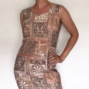 May include: A sleeveless brown and cream dress with a geometric pattern. The dress has a scoop neck and a straight silhouette.