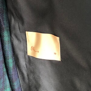 May include: A beige fabric label with the text "Bhs" and the number "10" printed in brown.