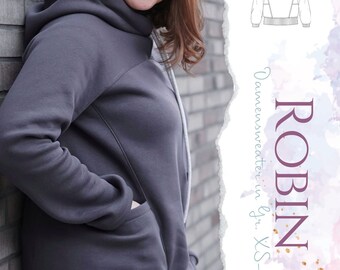 Puede incluir: Una sudadera gris con capucha, bolsillo lateral y bajo asimétrico largo. La sudadera se muestra en una modelo de pie contra una pared de ladrillo. La imagen también incluye un dibujo de línea del patrón de la sudadera.