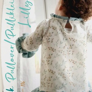 Könnte beinhalten: E-book für ein Pulloverkleid mit Blatt-Print und einem Rüschenkragen und -saum. Das Kleid ist für die Größen 80-116 cm. Der Text "E-book Pullover Pullkleid Lilly" ist in Türkis auf weißem Hintergrund geschrieben.