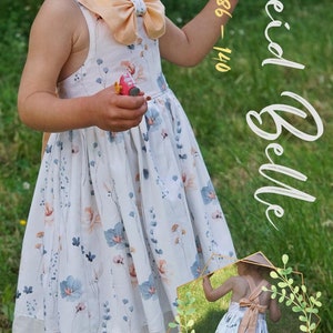 May include: A white dress with a floral print and a peach colored bow. The dress has a lace trim and is for sizes 86-140 cm.